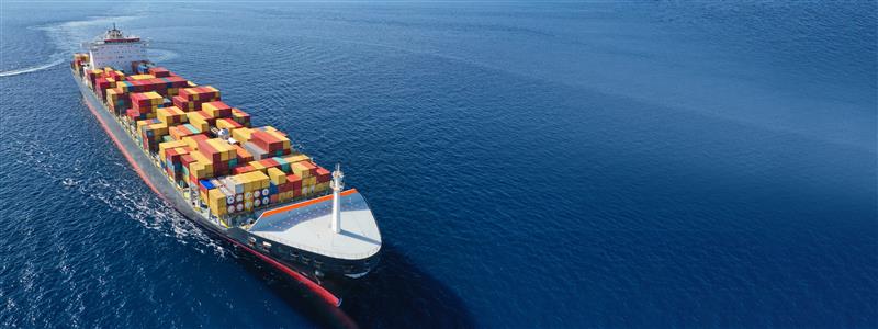 A cargo ship in the middle of the ocean surrounded by blue water